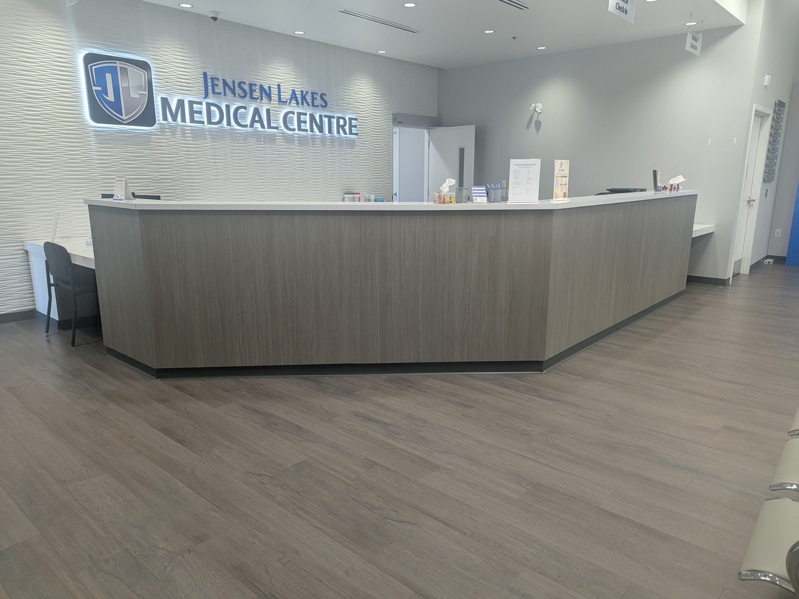 The Jensen Lakes Medical Centre reception desk with the illuminated sign behind it