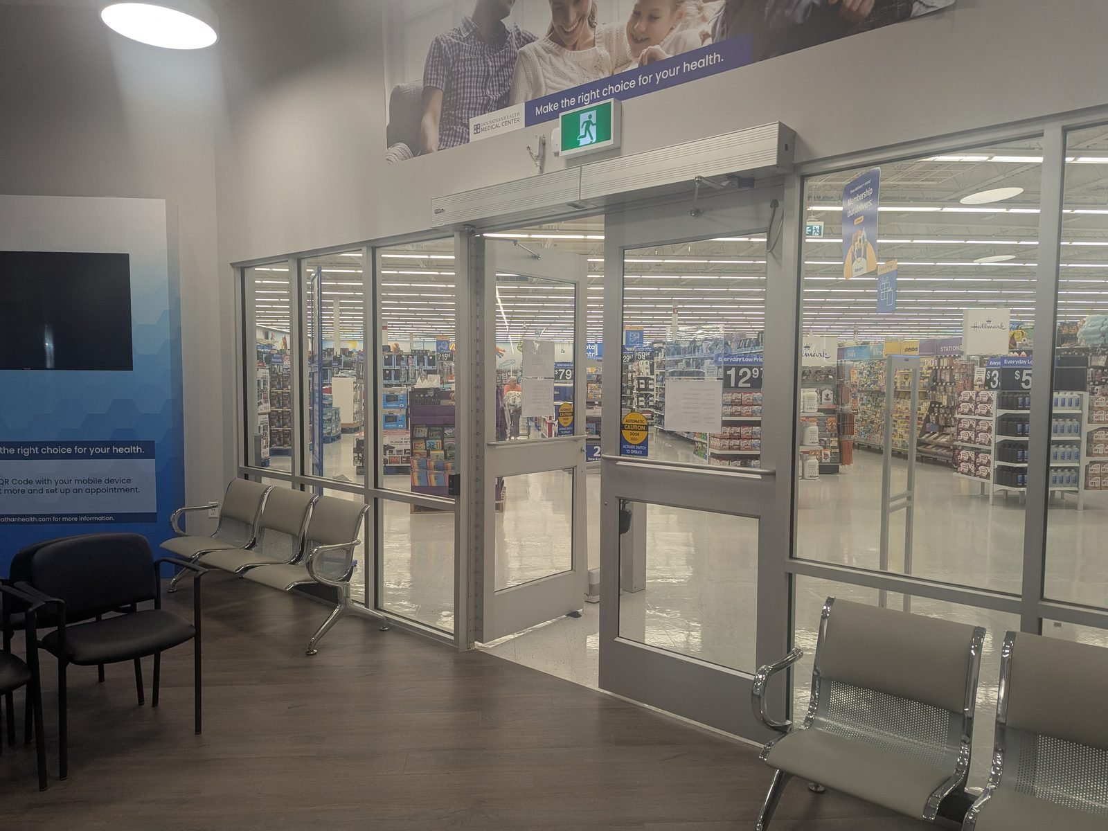 The glass entrance doors into the medical centre, seen from the waiting area