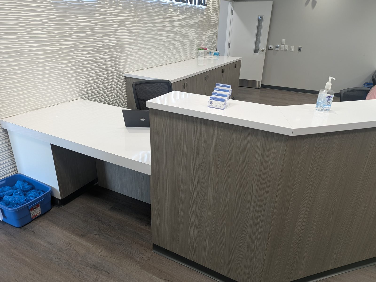 The reception counter with a textured feature wall behind it