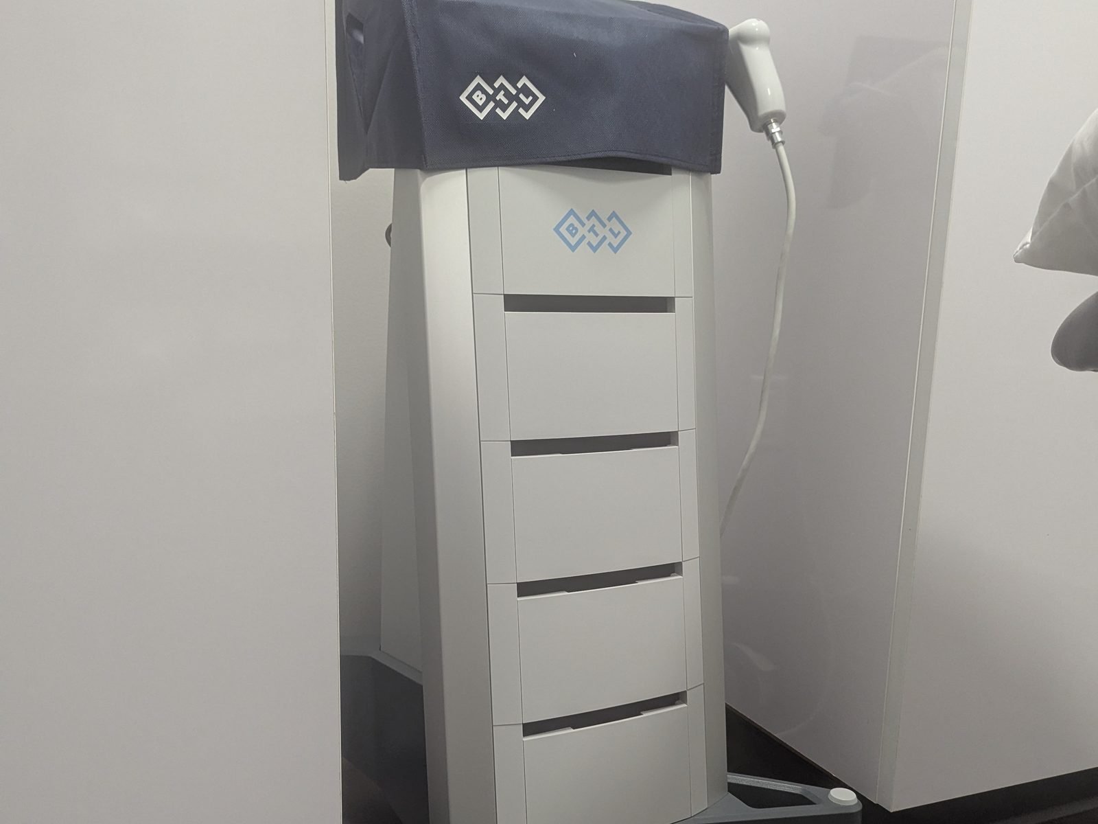 A therapy unit on a wheeled cart beside a treatment plinth