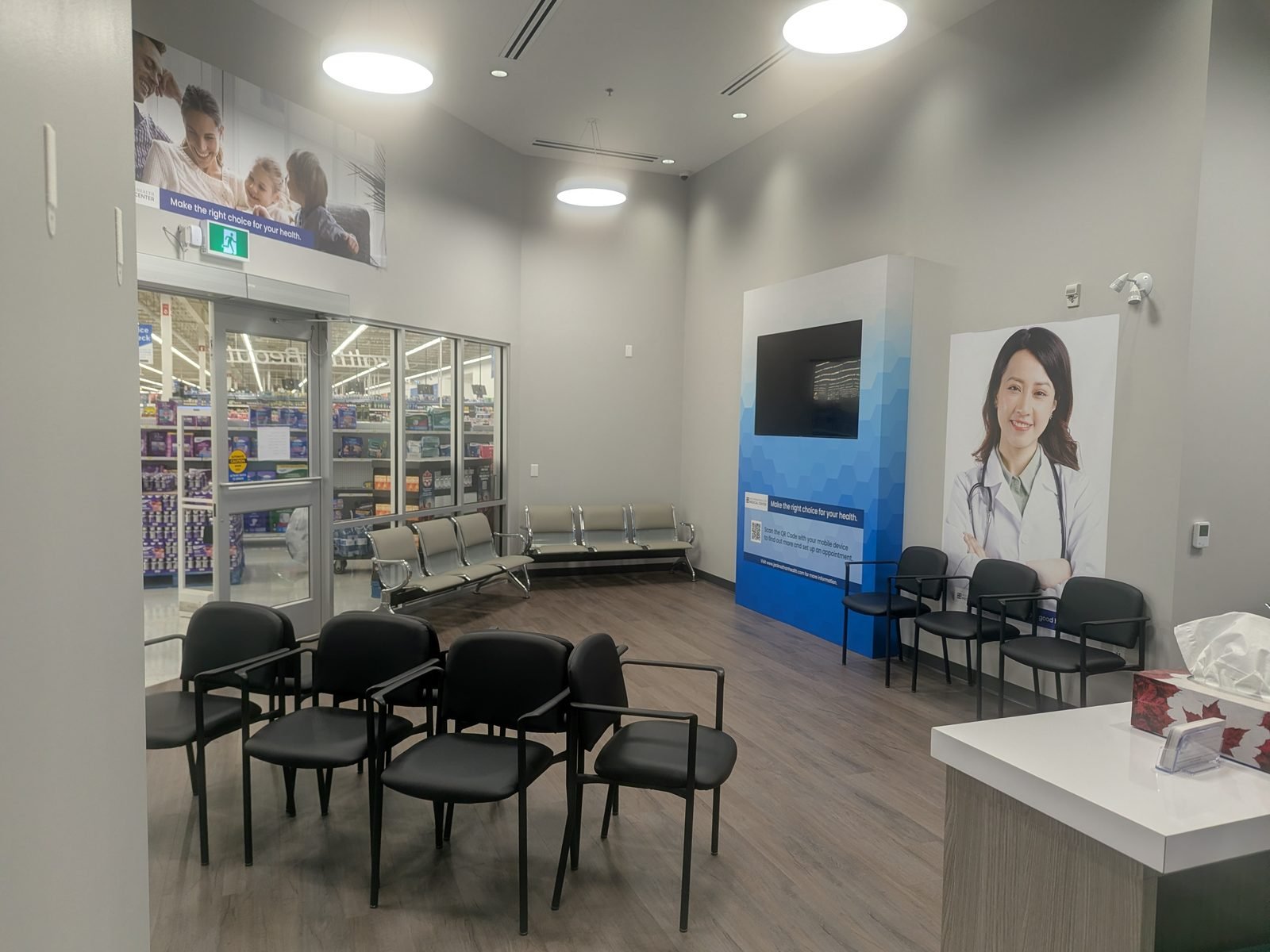 The medical centre waiting area with seating and a pharmacy beyond