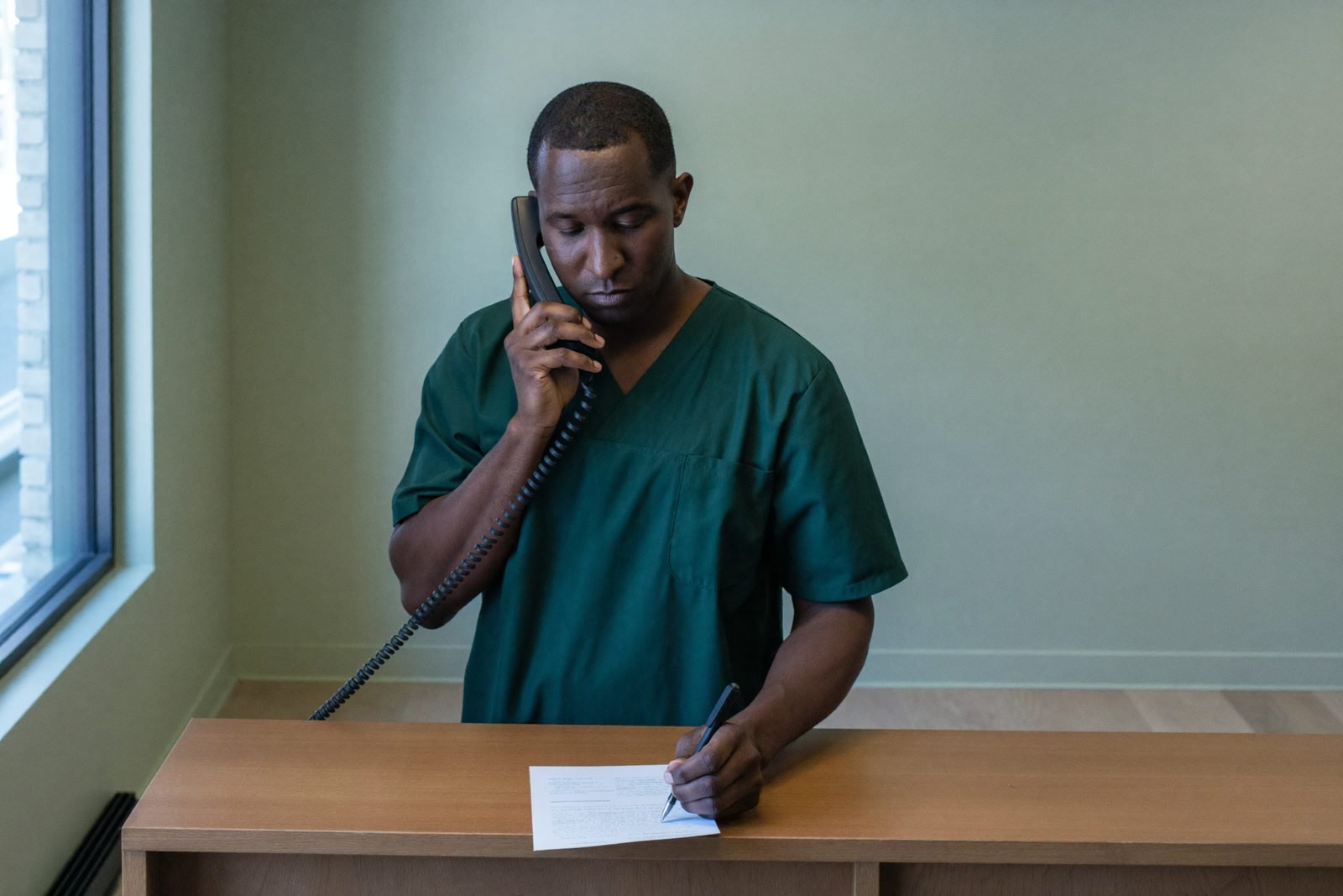 A member of the clinic team taking an enquiry over the phone at reception