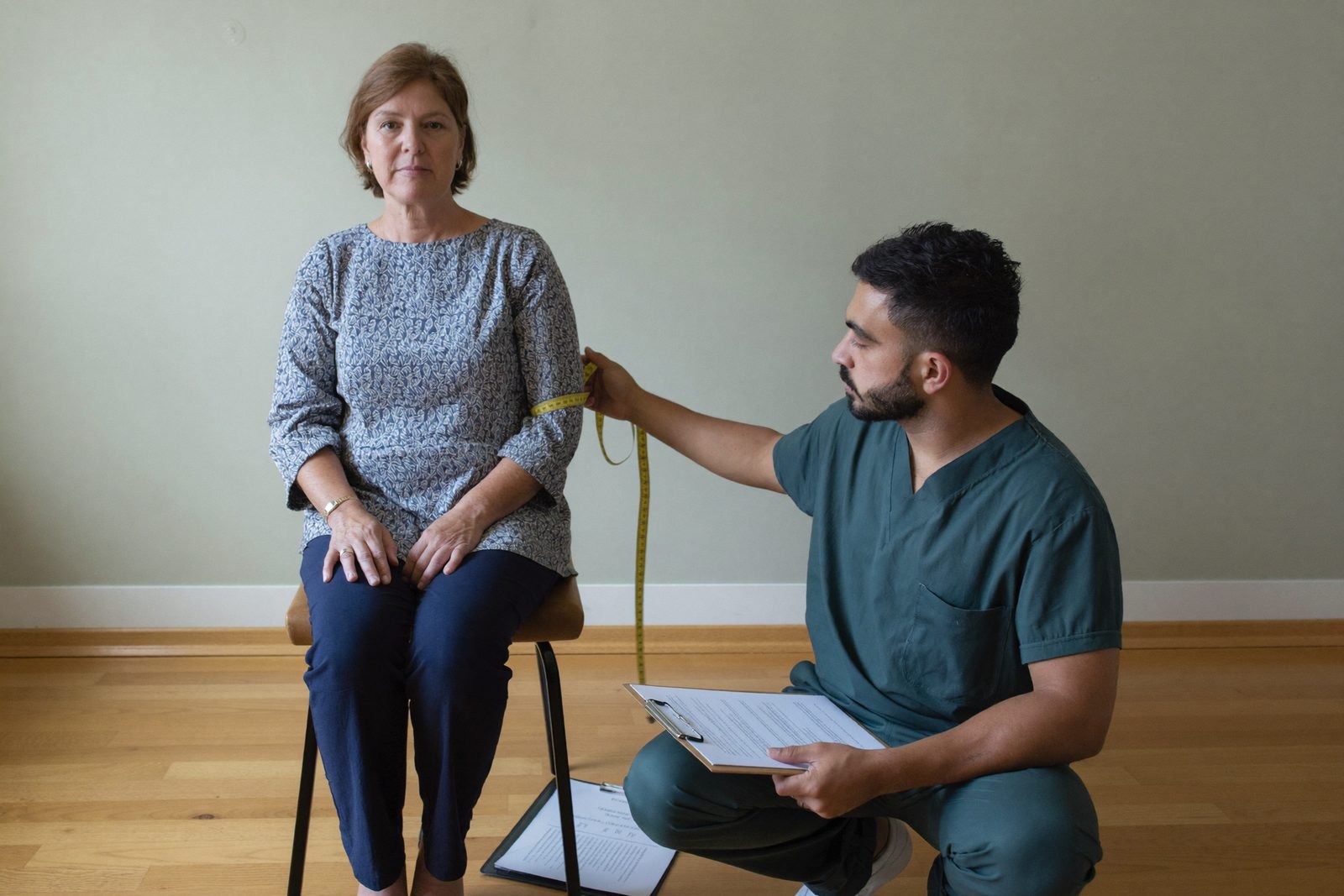 Clinician measuring a patient’s arm with a tape measure