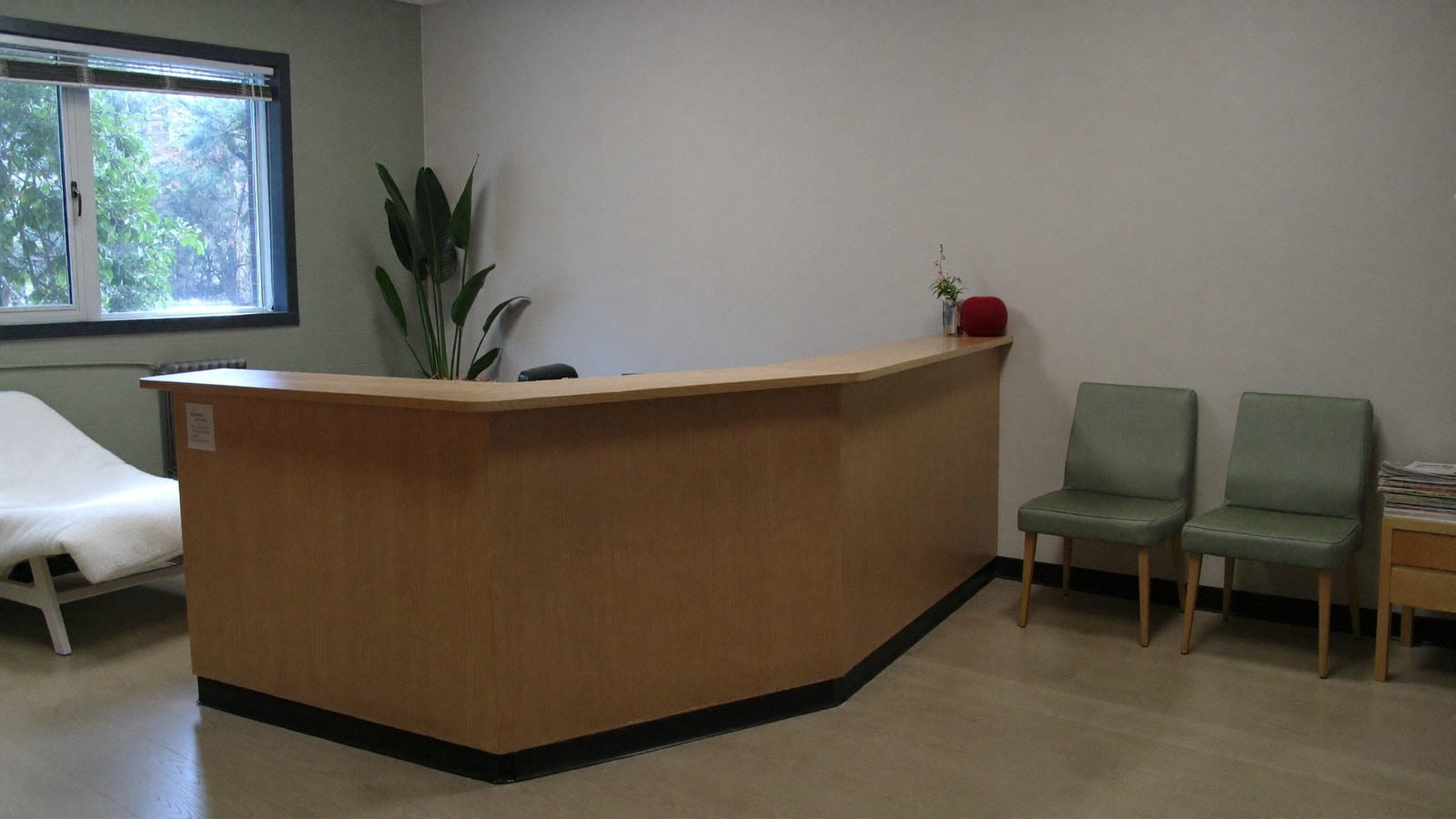 The clinic reception, with the counter, waiting chairs and daylight from the window