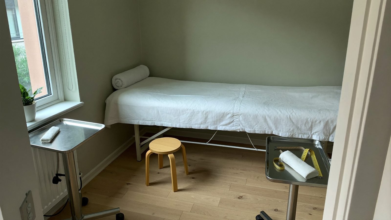 A treatment room at the clinic with the table made up and the tray set out
