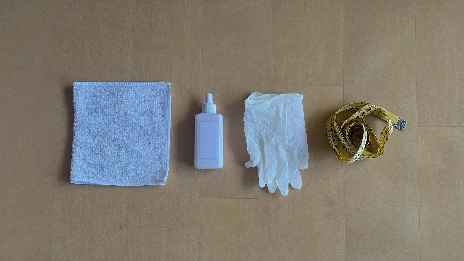 A folded towel, gloves, a measuring tape and gel laid out before a physiotherapy appointment