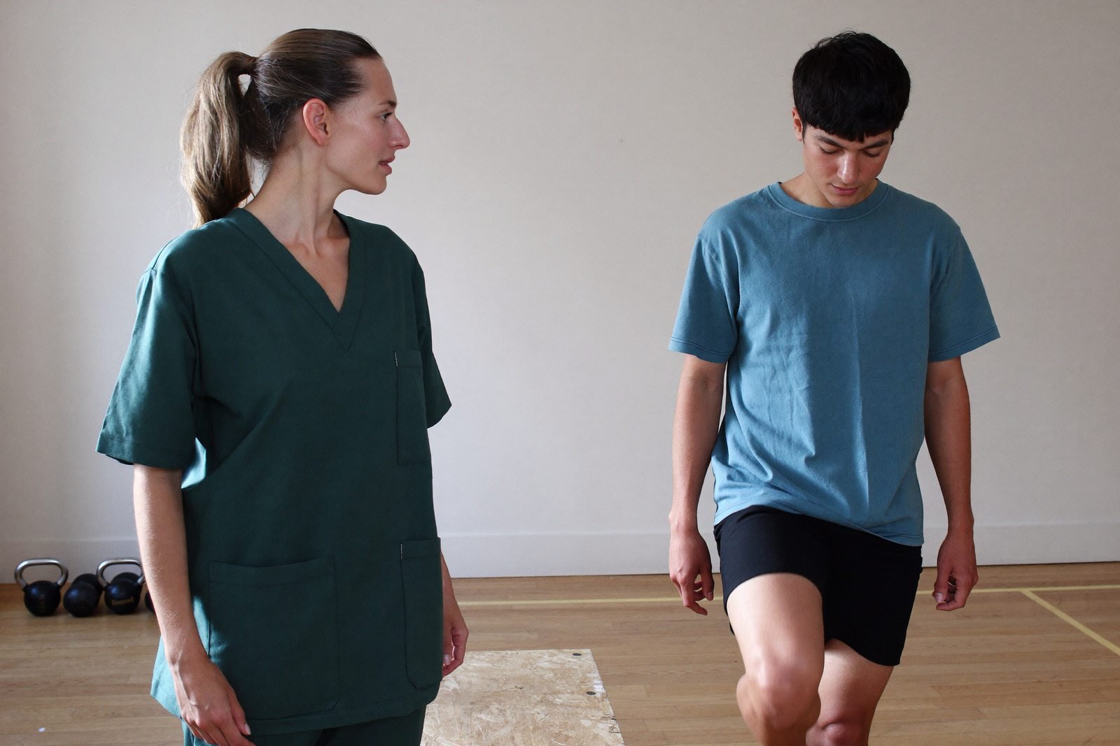 A clinician watching a patient perform a step-up during a movement assessment