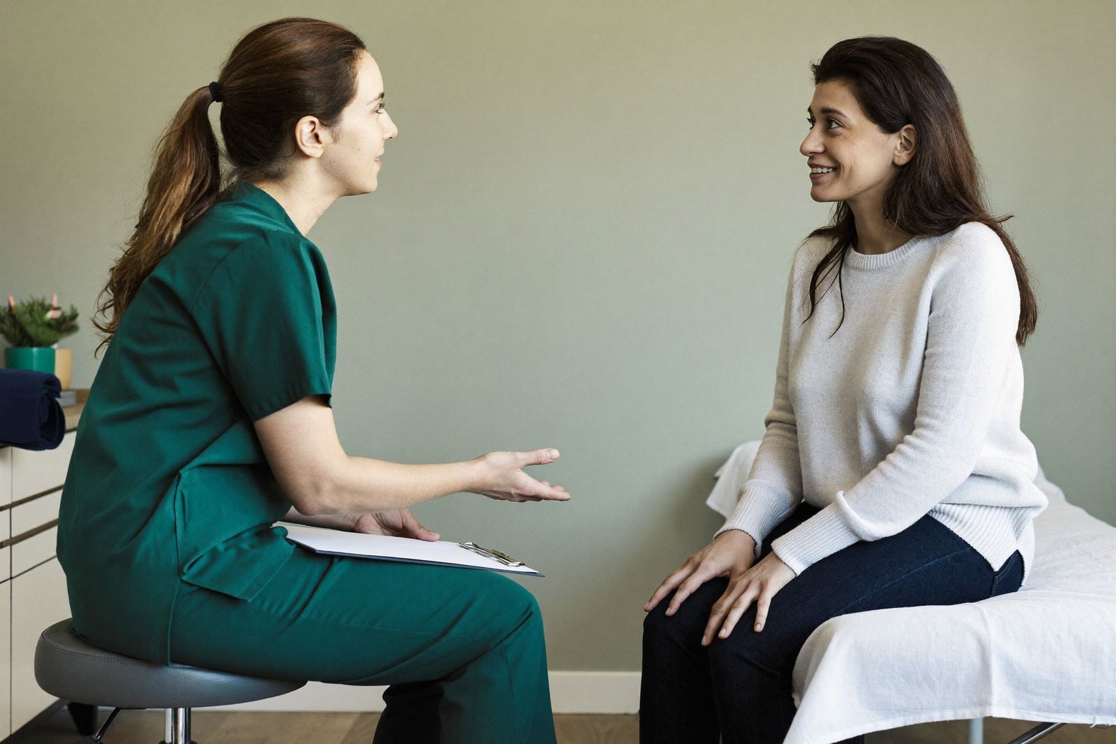 A pelvic health physiotherapist and patient talking at eye level during an assessment